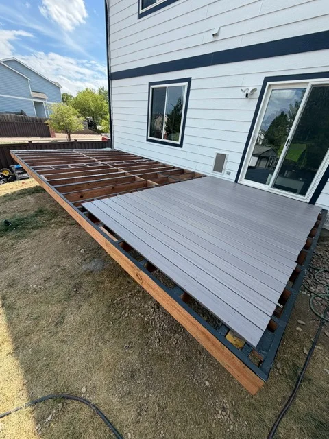 Composite deck with gray boards and exposed pressure-treated frame during construction phase